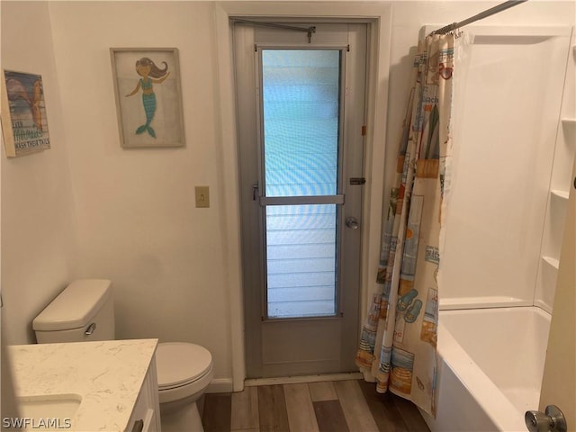 bathroom with vanity, wood finished floors, toilet, and shower / bathtub combination with curtain