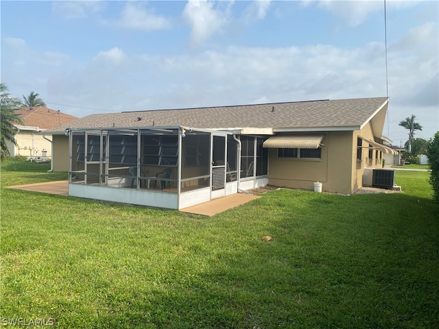 back of property with a sunroom, a yard, and central air condition unit