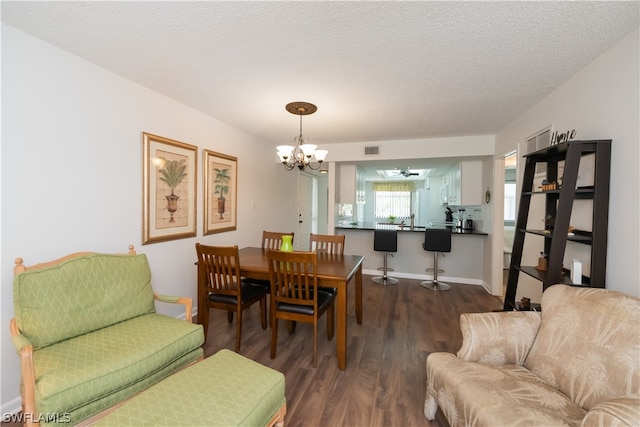 dining space featuring hardwood / wood-style floors, a textured ceiling, and a notable chandelier