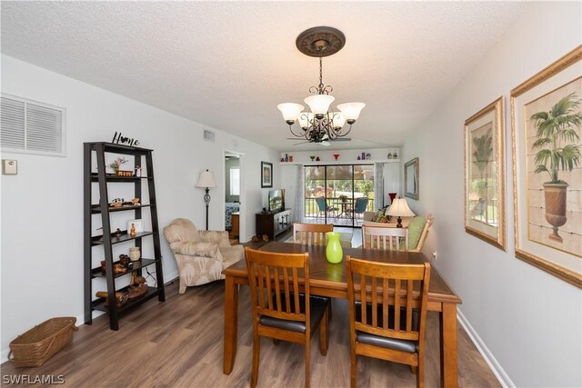 dining area featuring a chandelier, a textured ceiling, and dark hardwood / wood-style floors