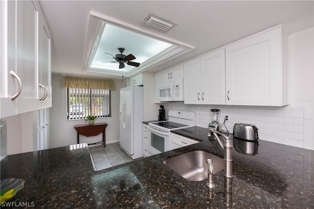 kitchen featuring white appliances, white cabinetry, dark stone countertops, and sink