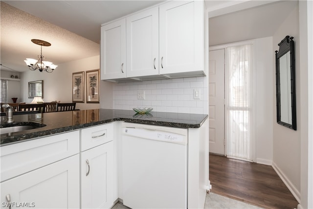 kitchen featuring dishwasher, a barn door, dark stone countertops, and white cabinetry