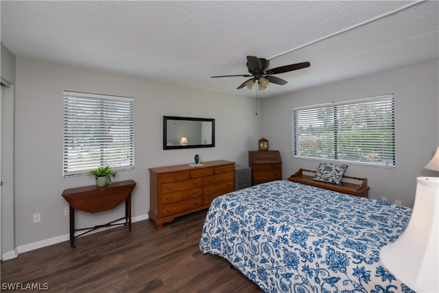 bedroom featuring a textured ceiling, dark hardwood / wood-style flooring, multiple windows, and ceiling fan