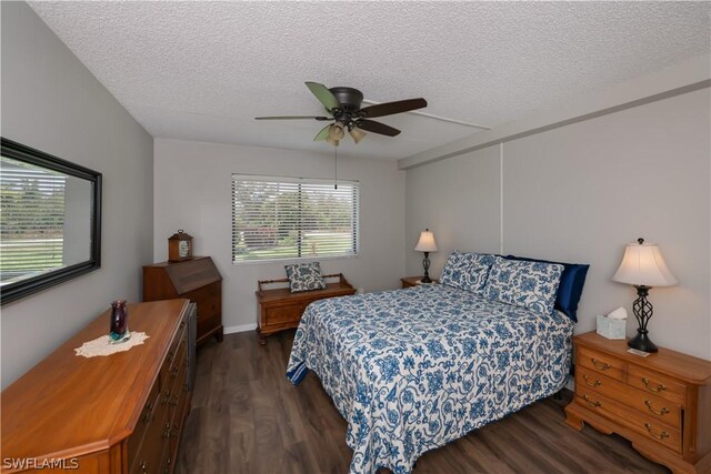 bedroom featuring ceiling fan, dark wood-type flooring, and a textured ceiling