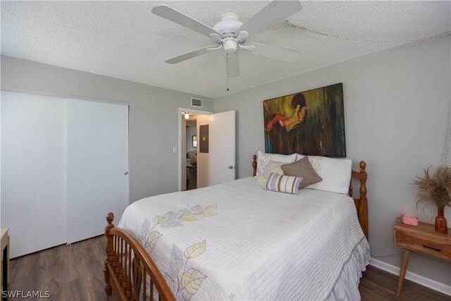 bedroom featuring ceiling fan, dark wood-type flooring, and a textured ceiling