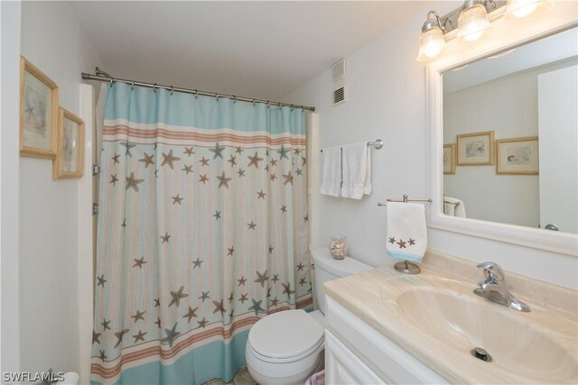 bathroom with vanity, a shower with shower curtain, and toilet