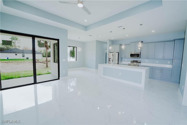 kitchen featuring appliances with stainless steel finishes, hanging light fixtures, a large island, and ceiling fan