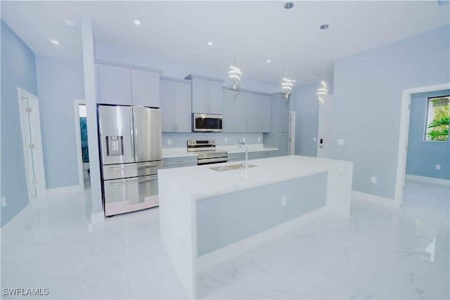 kitchen featuring sink, a center island with sink, hanging light fixtures, and appliances with stainless steel finishes