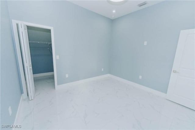 unfurnished bedroom with a walk in closet and a closet