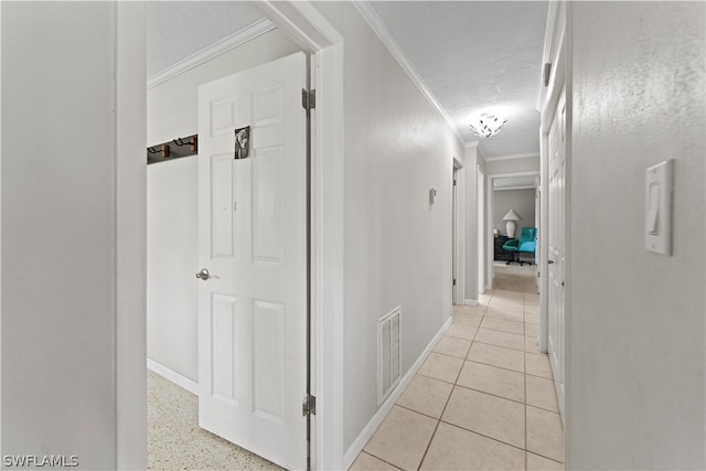 hallway featuring ornamental molding and light tile floors