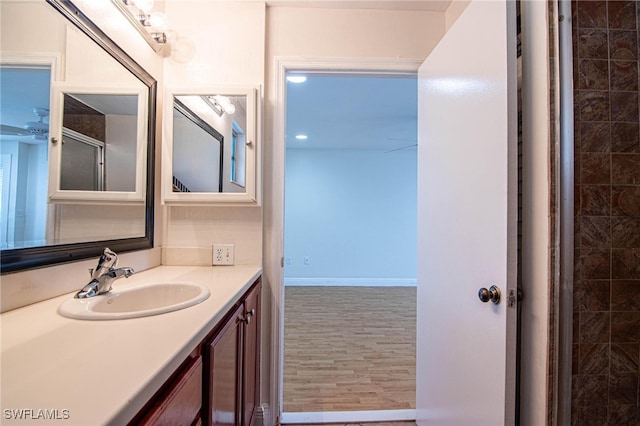 bathroom featuring hardwood / wood-style flooring, a shower with door, and vanity