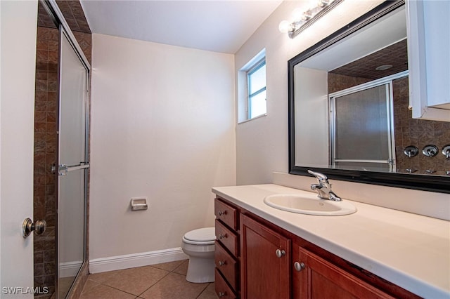 bathroom featuring toilet, vanity, tile patterned flooring, and a shower with shower door