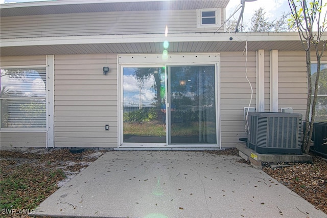 entrance to property with central AC unit and a patio