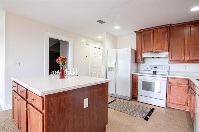 kitchen featuring a center island, white appliances, and light tile patterned floors