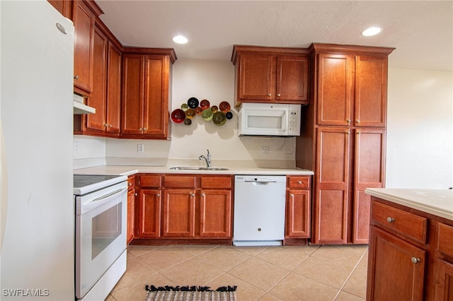 kitchen with white appliances, sink, and light tile patterned floors