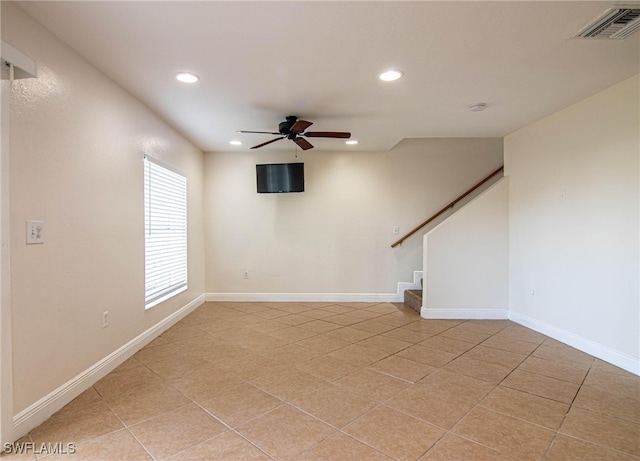 tiled spare room with ceiling fan