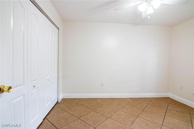 unfurnished bedroom featuring light tile patterned flooring, ceiling fan, and a closet