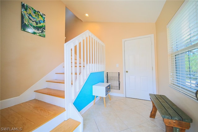 stairs with tile patterned floors and lofted ceiling