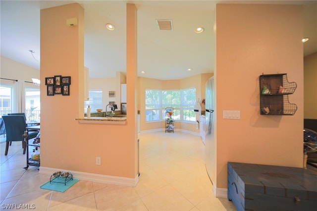 corridor with light tile patterned floors and sink