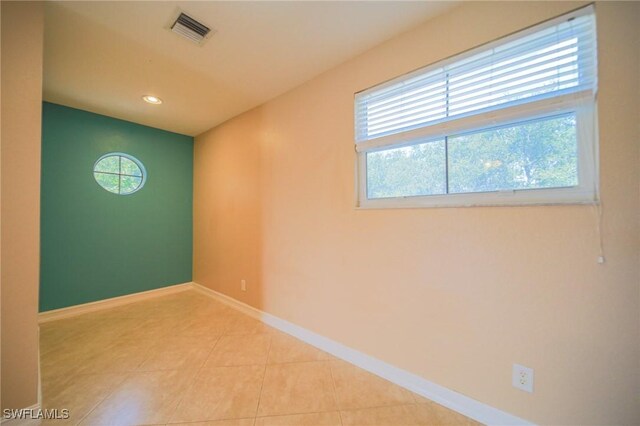 tiled spare room featuring a wealth of natural light