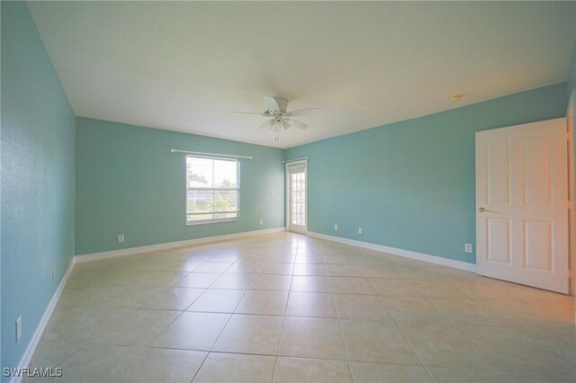 tiled empty room featuring ceiling fan