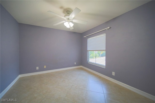 empty room with ceiling fan and light tile patterned flooring