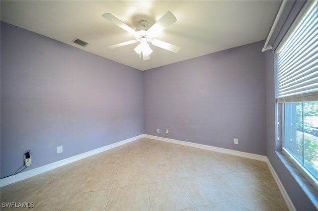 unfurnished room with ceiling fan and light tile patterned flooring