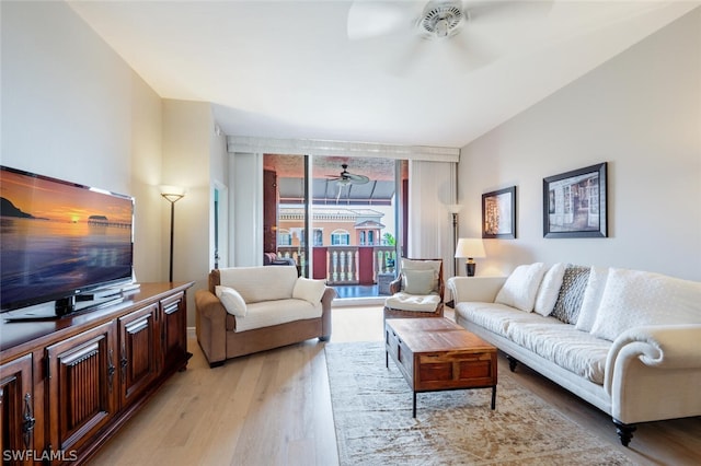 living room with light hardwood / wood-style floors, ceiling fan, and floor to ceiling windows