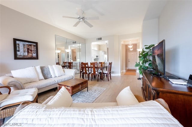 living room with light hardwood / wood-style flooring and ceiling fan