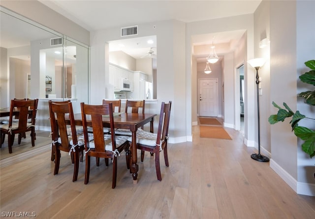 dining space with ceiling fan and light hardwood / wood-style floors