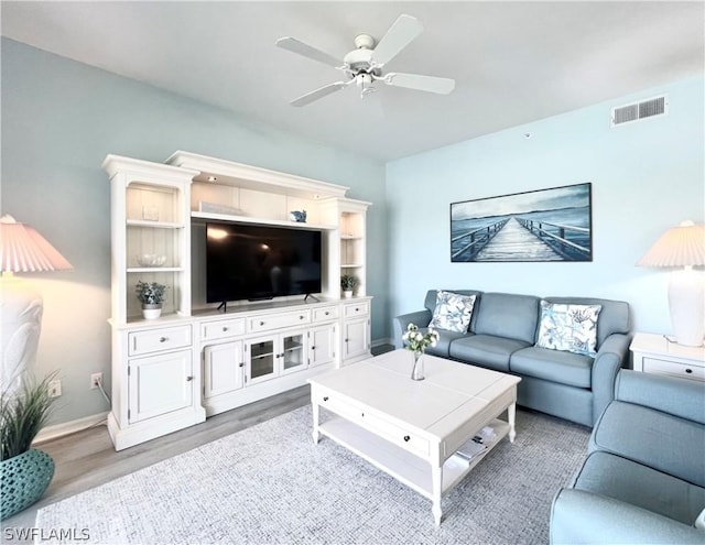 living room featuring hardwood / wood-style floors and ceiling fan