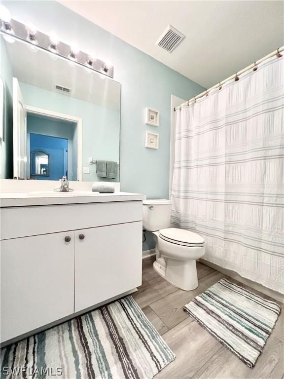 bathroom with vanity, hardwood / wood-style flooring, and toilet