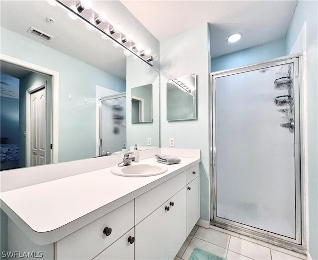 bathroom with tile patterned flooring, vanity, and a shower with door