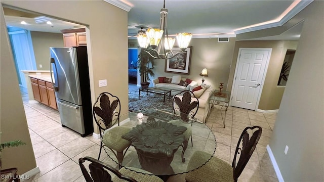 tiled dining space with ornamental molding and a chandelier