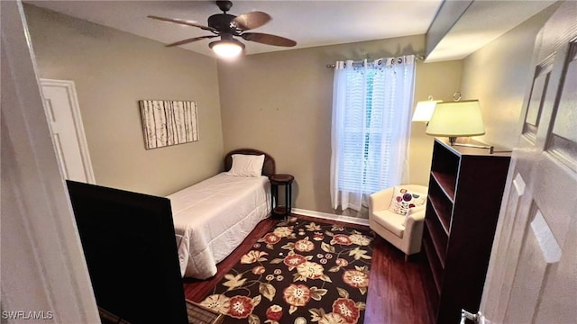 bedroom with dark hardwood / wood-style flooring and ceiling fan