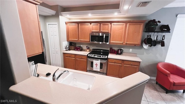 kitchen featuring a raised ceiling, light tile patterned flooring, appliances with stainless steel finishes, and sink