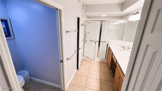 bathroom featuring vanity, a shower with shower door, tile patterned floors, and toilet