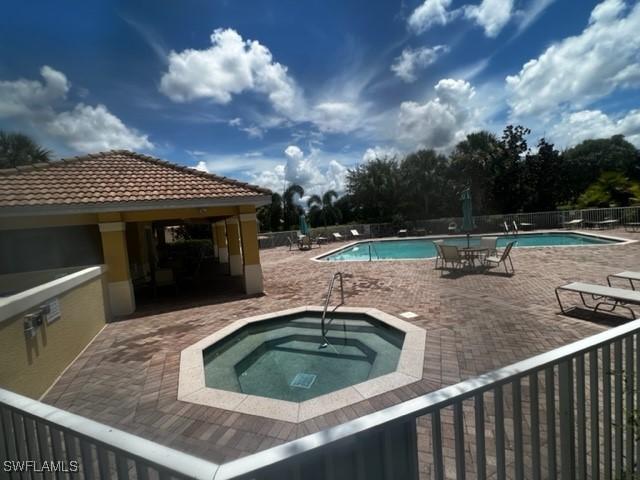 view of pool with a patio and a community hot tub