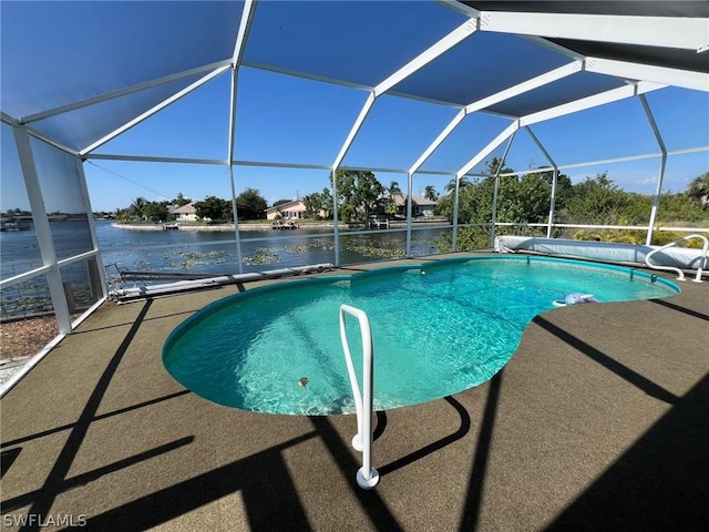 view of pool featuring a patio area, a water view, and glass enclosure