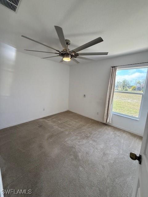 carpeted spare room with ceiling fan