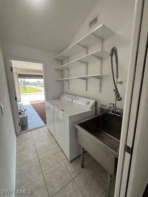 laundry room featuring sink, washer and dryer, and light tile patterned flooring