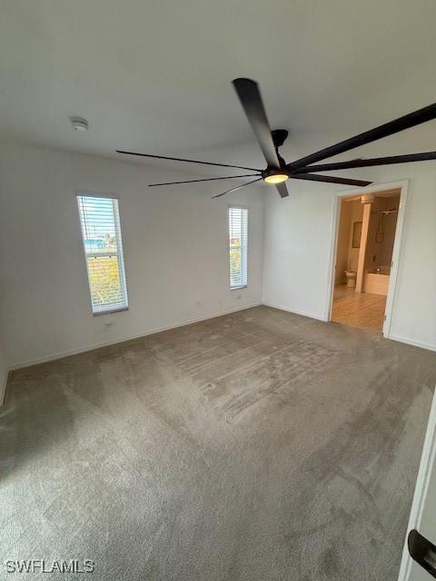 empty room featuring ceiling fan and light colored carpet