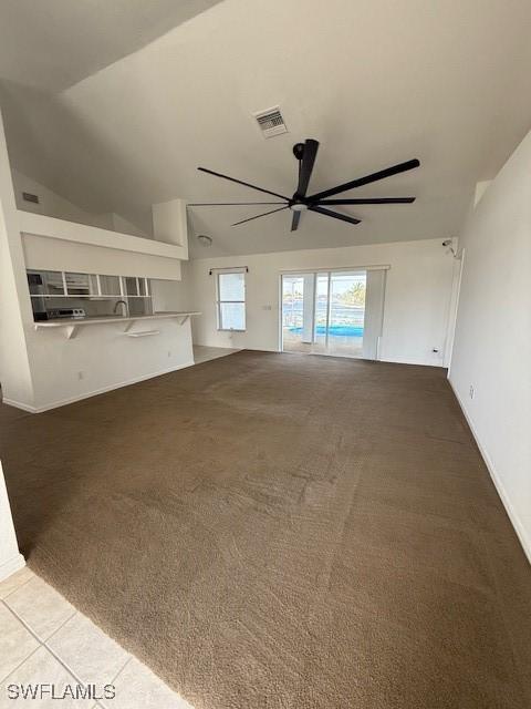 unfurnished living room featuring ceiling fan and carpet floors