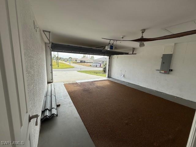 garage with a garage door opener and electric panel