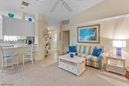 living room featuring lofted ceiling, ceiling fan, and light tile patterned floors