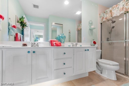 bathroom with vanity, a shower with shower door, toilet, and tile patterned floors