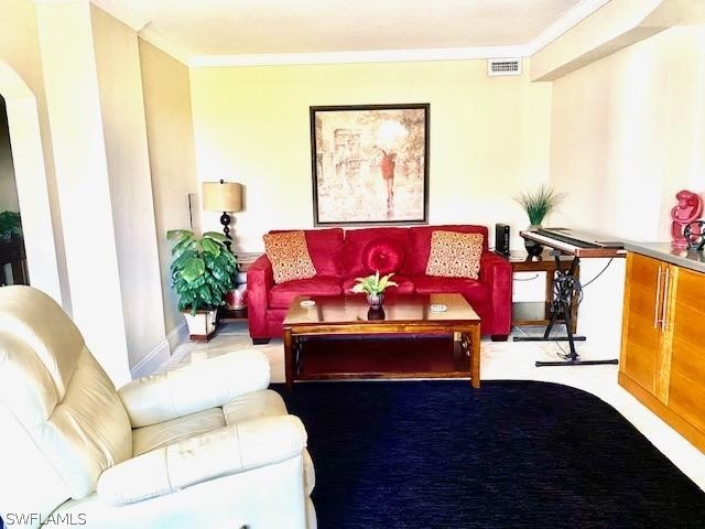 carpeted living room featuring crown molding