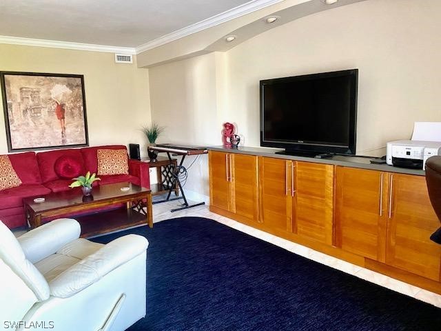 living room featuring visible vents and crown molding