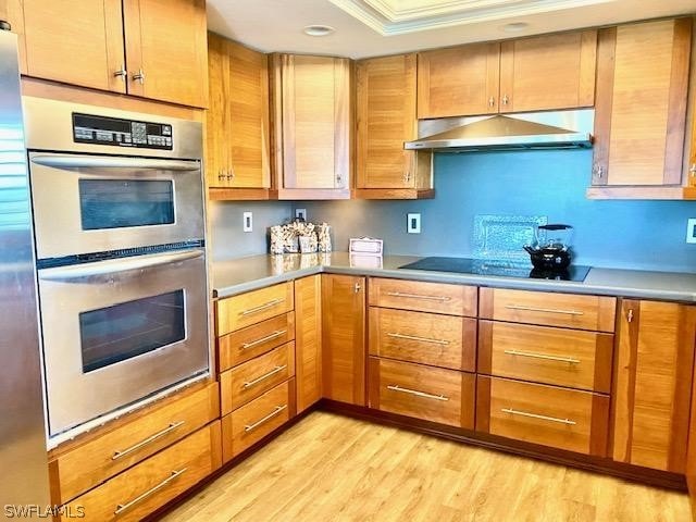 kitchen with black electric stovetop, light hardwood / wood-style floors, double oven, and ornamental molding