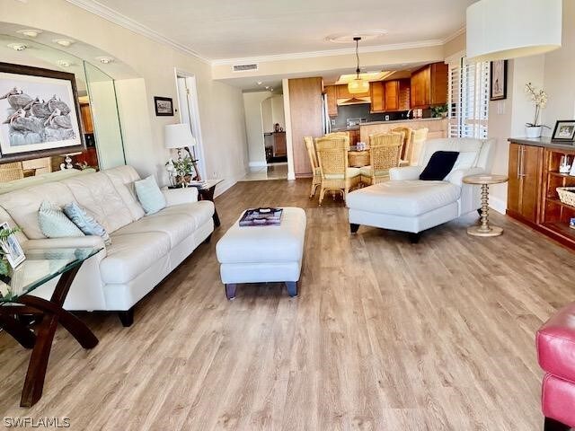 living room with light hardwood / wood-style floors and crown molding